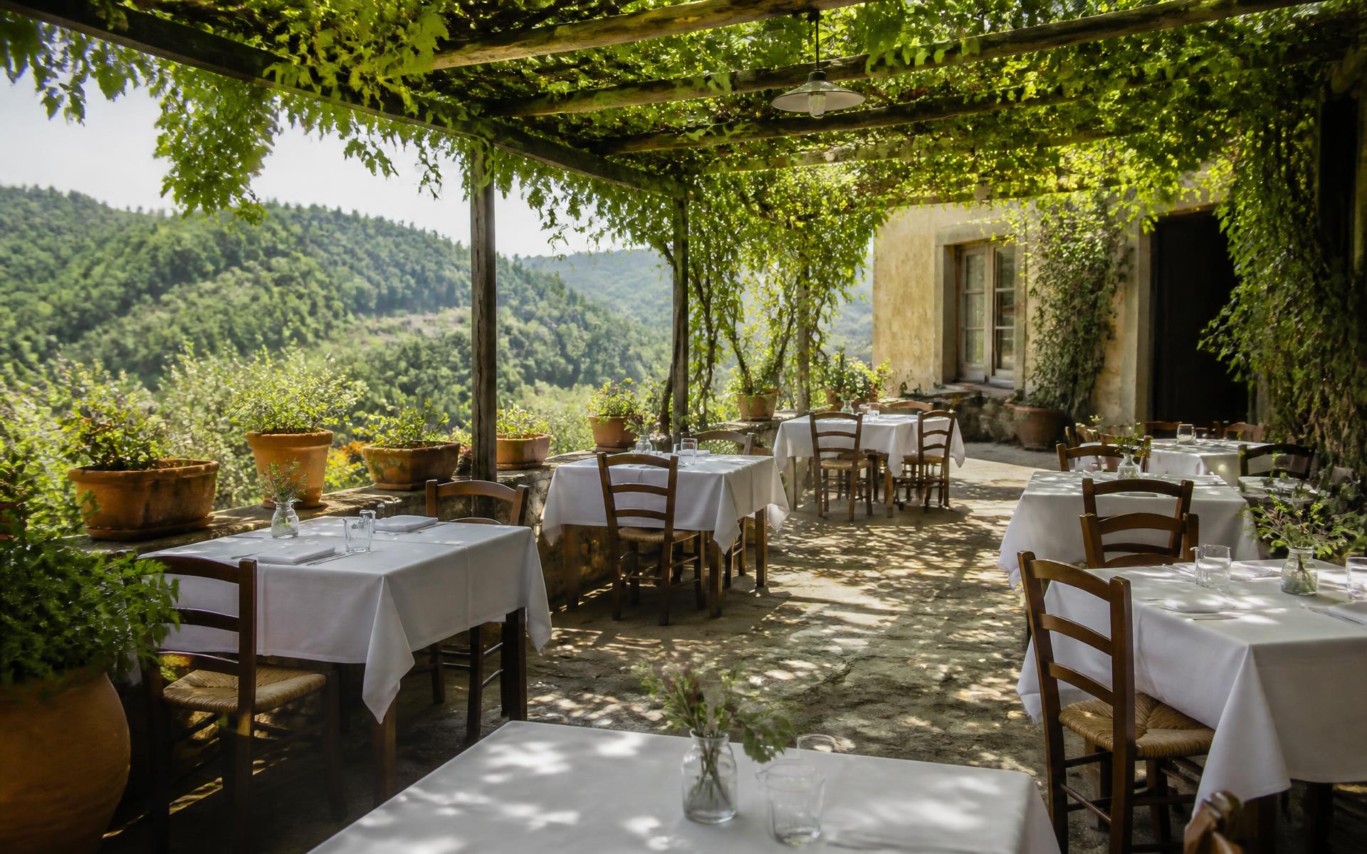 Tavoli apparecchiati nel giardino sotto il pergolato